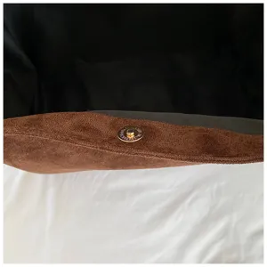 Brown suede tote bag detail, featuring gold magnetic snap closure and black interior lining.