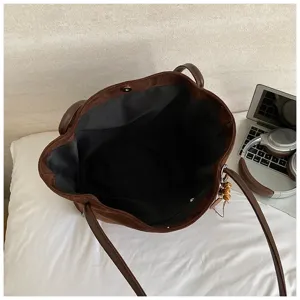 Detail shot of brown suede tote bag interior, showing large capacity and black lining.