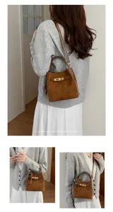 Brown suede bucket bag detail showing metal lock closure and strap, perfect for daily commuting.