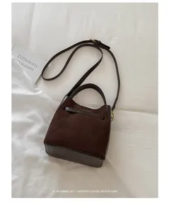 Gedetailleerd overzicht van een chique donkerbruine suède bucketbag voor dagelijks gebruik.