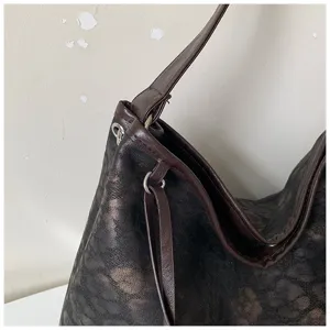 Gedetailleerde close-up van de vintage schoudertasriem en de metalen ring hardware.