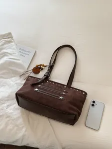 Brown suede tote bag with metal studs and tassel charm detail, vintage shoulder bag style.