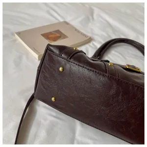 Primer plano de los detalles del bolso de cuero marrón oscuro retro con tachuelas y herrajes.