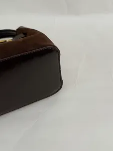 Detailweergave van bruine suède en lakleren emmertas, close-up van casual dagelijkse schoudertas.