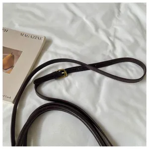 Detalle de correa de cuero marrón oscuro para bolso retro, accesorio de hombro elegante.
