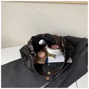 Gedetailleerd uitzicht op het interieur van de grote luipaardprint tas met dagelijkse items.