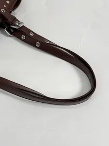 Brown retro women underarm bag metal eyelets rivet strap detail close-up stylish daily wear