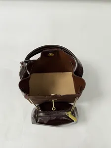 Gedetailleerd uitzicht van de bruine emmertas van boven met binnenkant en klein tasje.