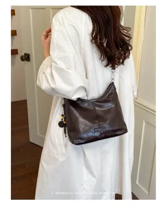 Minimalist brown shoulder hobo bag for women, retro chic dumpling style handbag with charm.