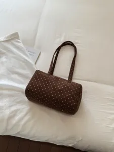 Sac bandoulière cylindrique à pois marron, détail de sac cabas chic et décontracté.