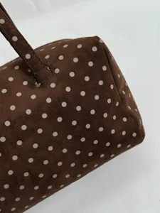 Sac Boston à pois en suédine marron vue de détail, texture douce et design rétro élégant.