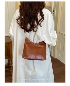 Detail view of the retro brown leather hobo shoulder bag, showing soft texture and elegant design.