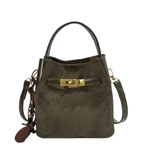 Dark green suede handbag with glossy leather trim, metal lock and wood bead charm.