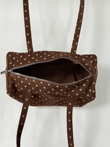 Vue rapprochée détaillée du sac à main marron à pois montrant la fermeture éclair texture.