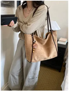 Large capacity suede tote bag for women, vintage commuting shoulder bag with chic wooden pendant.