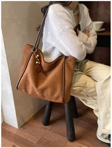 Retro large capacity suede shoulder bag for women, stylish commuting tote with pendant.
