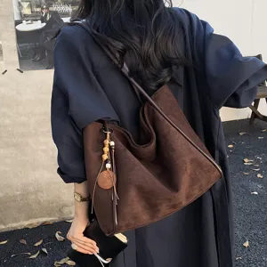 Vintage suede shoulder tote bag for women, large capacity casual commuting handbag with charm.