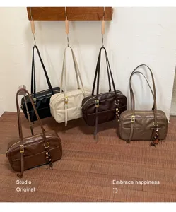 Detailed view of vintage leather shoulder bags in multiple colors, hanging and displayed.
