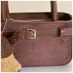 Elegant brown suede handbag for women, featuring a chic belt buckle and dual top handles.