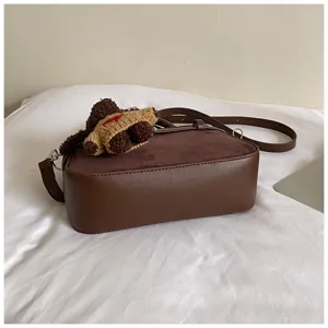 Dark brown frosted shoulder crossbody bag detail showing rich texture and cute knit bear charm.