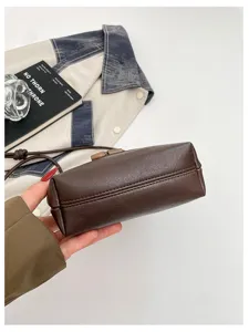 Detailed view of the brown leather shoulder bag bottom and stitching craftsmanship.