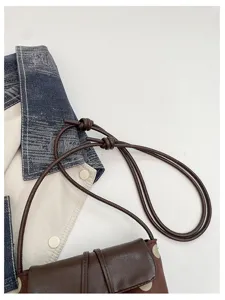 Minimalist women bucket shoulder bag with elegant thin knotted strap detail for autumn chic style.