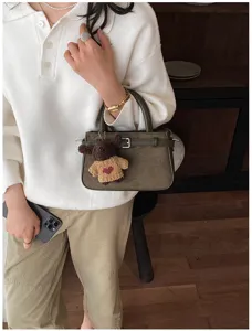 Trendy dark green matte handbag for women, chic commuter shoulder bag with cute bear charm.