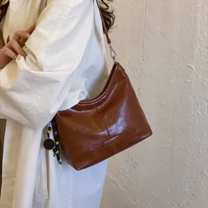 Brown leather shoulder bag for women, stylish hobo dumpling purse with chic minimalist design.