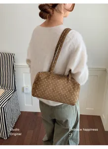Gros plan du sac à main Boston marron à pois, montrant la texture du tissu et doubles brides.