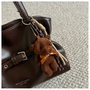 Brown PU leather tote bag detail with cute bear pendant, stylish minimalist shoulder bag.