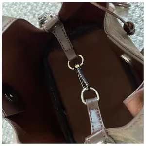 Detailansicht des braunen Damen Beuteltaescheninnenraums mit Metallverschluss und schickem Design.