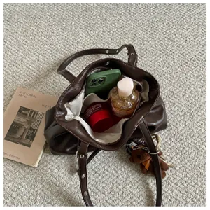 Brown PU leather tote bag detail showing gathered design and organized essentials.