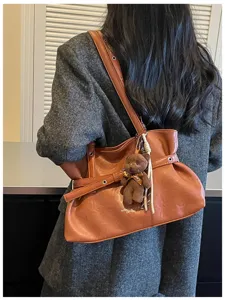 Stylish brown PU leather tote shoulder bag with cute bear charm for women daily commuting.