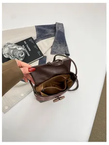 Detail view of brown crossbody bag interior, showing compartments and lining structure clearly.