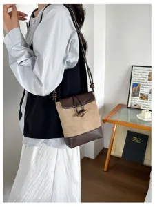 Detailed view of the stylish contrast color bucket bag with toggle closure and shoulder strap.