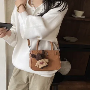 Stylish brown suede women shoulder crossbody bag with cute bear pendant for daily commute.