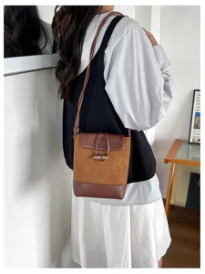 Detailed view of the vintage brown suede patchwork shoulder bag styled with model outfit.