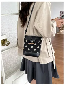 Chic black and white polka dot crossbody bag with chic wooden toggle closure for women fashion.