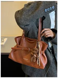 2026 Autumn fashion chic niche tote bag, simple PU leather commuting shoulder bag with bear charm.