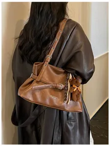 Brown leather shoulder bag tote with buckle strap and cute bear charm for daily commute.