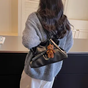 Black leather tote bag for women, stylish commuter shoulder bag with cute bear pendant.