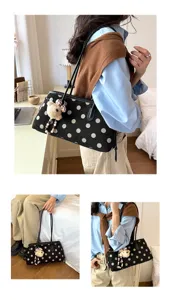 Detailed close-up view of the chic black polka dot underarm shoulder bag with cute bear charm.