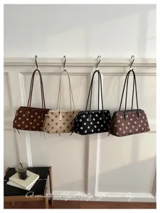 Detail view of vintage polka dot shoulder bags hanging on wall, elegant women casual bags.