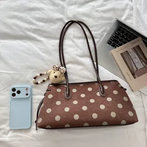 Brown polka dot shoulder bag for women, chic commuter underarm handbag with cute bear charm.