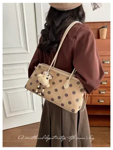 Detail view of vintage polka dot shoulder bag with cute bear charm, elegant back display.
