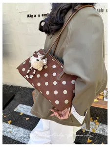 Vintage brown polka dot shoulder bag detail with cute bear pendant and sleek slim strap style.