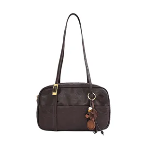 Brown vintage shoulder bag for women, stylish underarm bag with charm pendant.