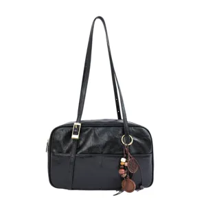 Black shoulder bag for women, retro underarm bag with decorative charms and long straps.