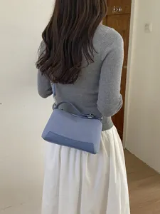 Detail view of the blue shoulder bag worn on model, showing daily commute style and design.