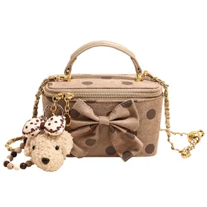 Brown polka dot vanity crossbody bag with chain strap and cute puppy pendant for women.